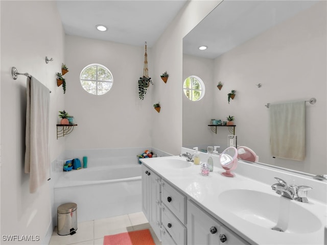 bathroom featuring a garden tub, double vanity, a sink, and tile patterned floors