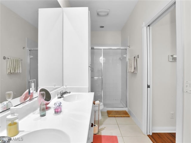 full bath featuring a stall shower, a sink, toilet, and tile patterned floors