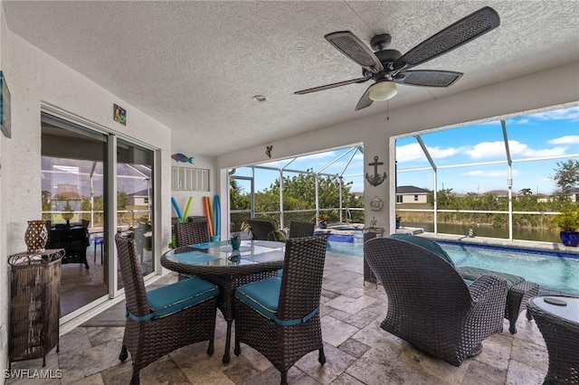 sunroom / solarium featuring a water view, a pool, and ceiling fan