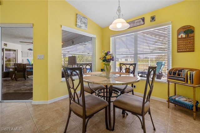 dining area with ceiling fan, vaulted ceiling, and light tile patterned floors