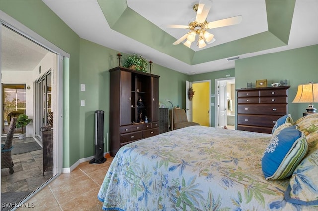 bedroom featuring a tray ceiling, access to outside, and ceiling fan