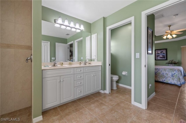 bathroom featuring a tile shower, vanity, ceiling fan, toilet, and tile patterned floors