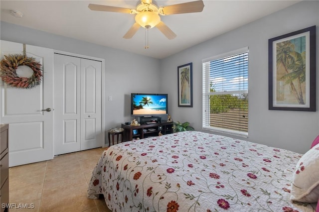 bedroom featuring light tile patterned floors, ceiling fan, and a closet