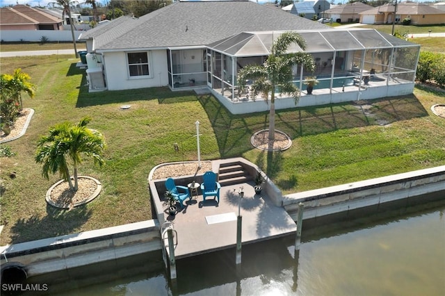 back of property with a yard, a lanai, a patio, and a water view