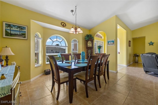 dining room featuring light tile patterned flooring, lofted ceiling, and a chandelier