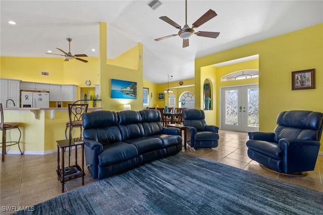 tiled living room featuring french doors, ceiling fan, sink, and high vaulted ceiling