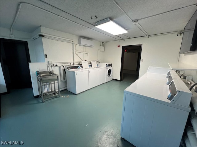 laundry room with a wall mounted air conditioner and washing machine and clothes dryer