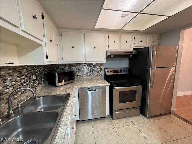 kitchen featuring sink, appliances with stainless steel finishes, white cabinetry, tasteful backsplash, and light tile patterned flooring