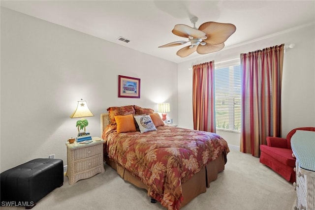 bedroom featuring visible vents, a ceiling fan, and light colored carpet