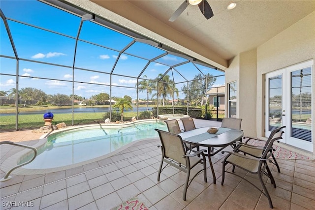 exterior space featuring a lanai, a water view, a pool with connected hot tub, and a ceiling fan