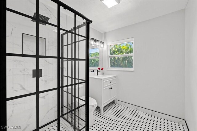 bathroom featuring a walk in shower, vanity, toilet, and tile patterned floors