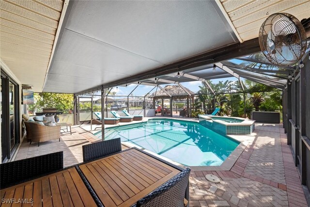 view of swimming pool featuring glass enclosure, an outdoor hangout area, a pool with connected hot tub, outdoor dining space, and a patio area