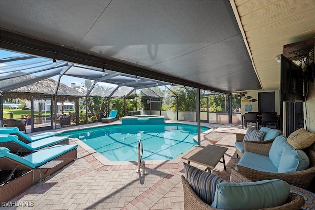 view of pool featuring a pool with connected hot tub, a lanai, outdoor lounge area, and a patio