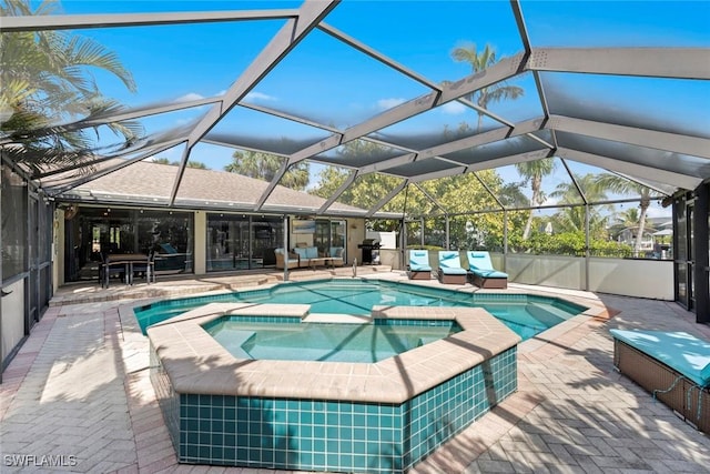 view of swimming pool featuring a patio area, a lanai, and a pool with connected hot tub