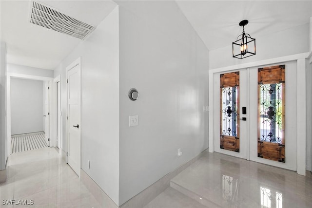 entryway featuring french doors, visible vents, and a notable chandelier