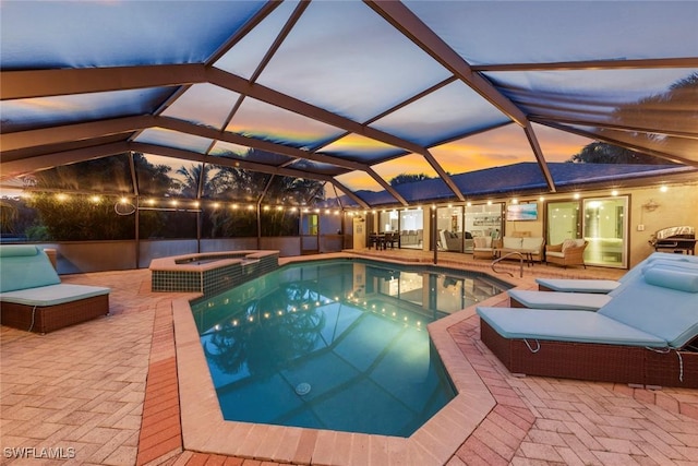 view of swimming pool featuring a patio area, glass enclosure, a pool with connected hot tub, and an outdoor living space