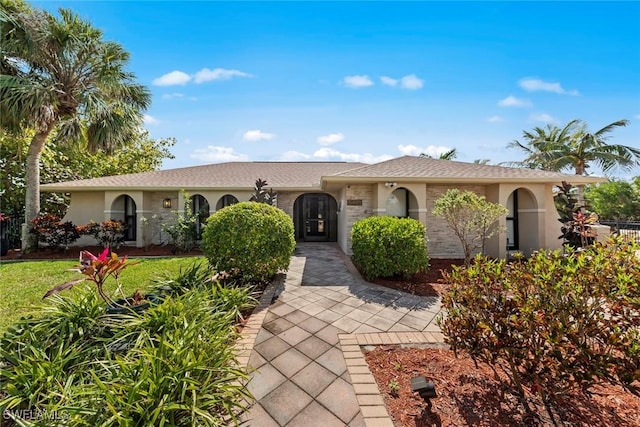 ranch-style house with a front yard and stucco siding