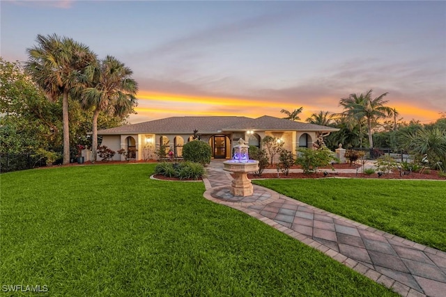 ranch-style home featuring a lawn