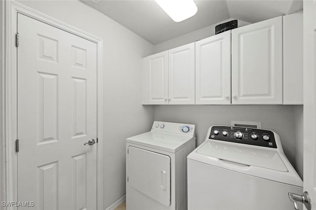 clothes washing area with cabinet space and independent washer and dryer