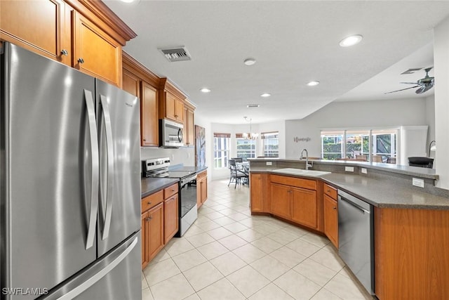 kitchen featuring light tile patterned flooring, stainless steel appliances, a sink, visible vents, and dark countertops