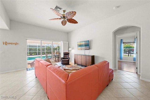 living room with light tile patterned floors, ceiling fan, visible vents, and baseboards