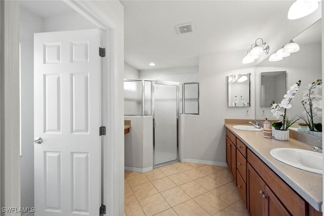 bathroom with double vanity, visible vents, a sink, a shower stall, and tile patterned floors