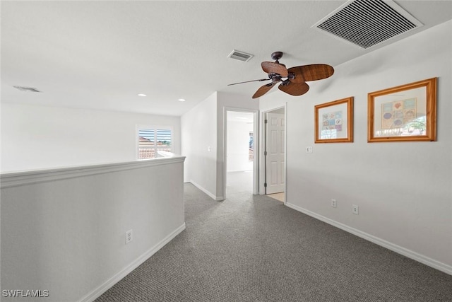 hallway with carpet floors, an upstairs landing, visible vents, and baseboards