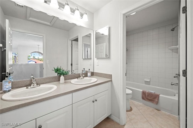 bathroom featuring double vanity, a sink, toilet, and tile patterned floors