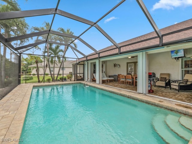 view of pool featuring ceiling fan, outdoor lounge area, glass enclosure, and a patio area