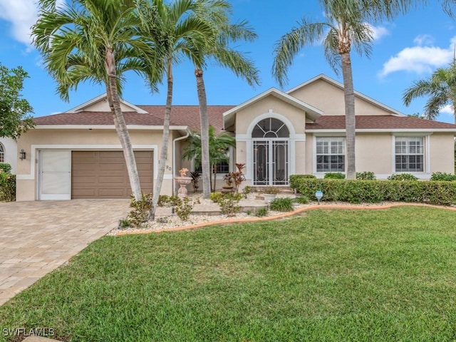 single story home featuring a garage and a front yard