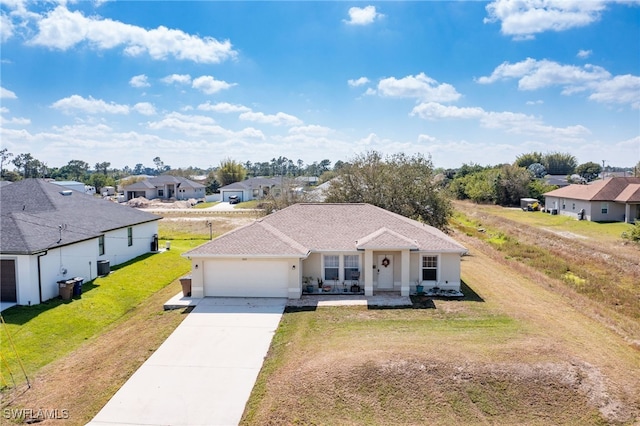 single story home with driveway, a garage, a residential view, and a front lawn