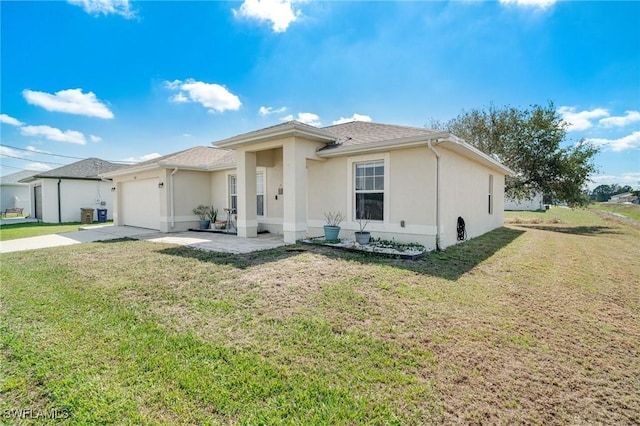 rear view of property featuring a garage, concrete driveway, a lawn, and stucco siding