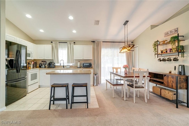 kitchen featuring lofted ceiling, white appliances, visible vents, white cabinetry, and light countertops