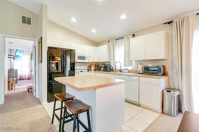 kitchen with light carpet, white appliances, visible vents, and light countertops