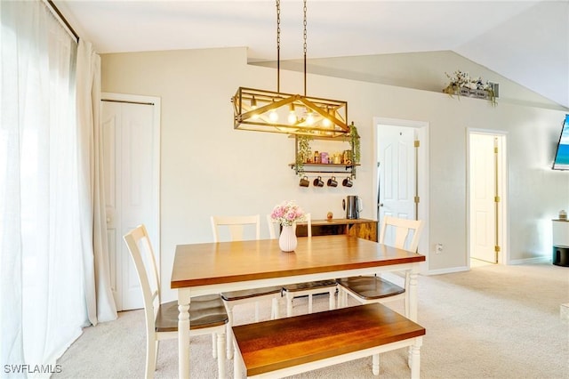 dining room featuring light carpet, vaulted ceiling, and baseboards