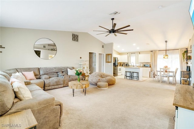 living area with light carpet, vaulted ceiling, visible vents, and ceiling fan