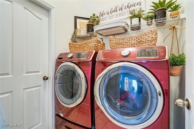 washroom featuring laundry area, tile patterned flooring, and separate washer and dryer