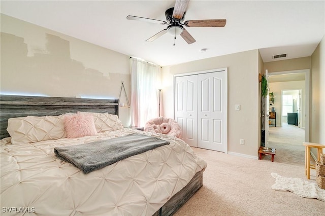 carpeted bedroom with baseboards, ceiling fan, visible vents, and a closet