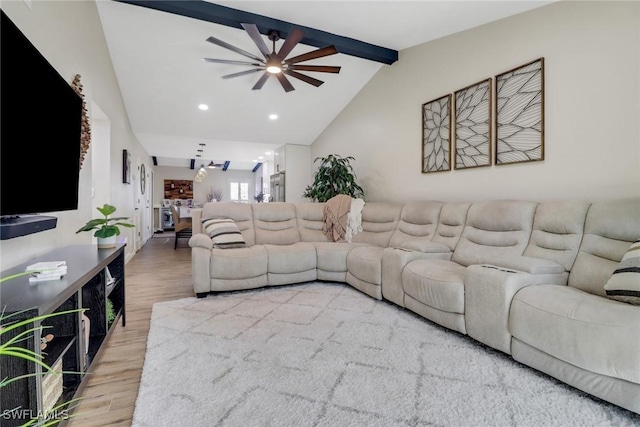 living room with hardwood / wood-style floors, vaulted ceiling with beams, and ceiling fan