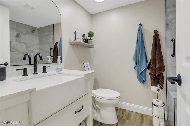 bathroom with vanity, an enclosed shower, hardwood / wood-style flooring, and toilet