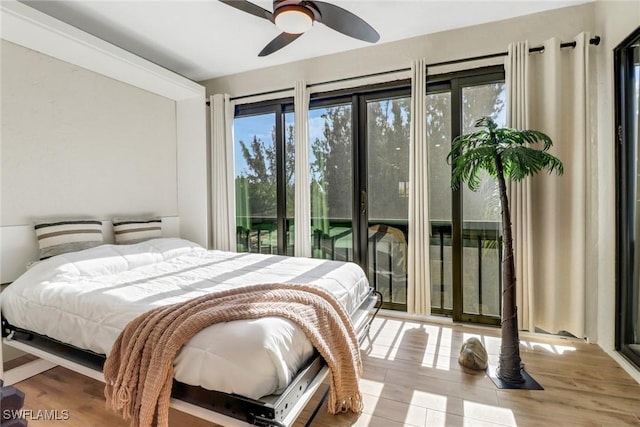 bedroom with access to exterior, hardwood / wood-style flooring, and ceiling fan