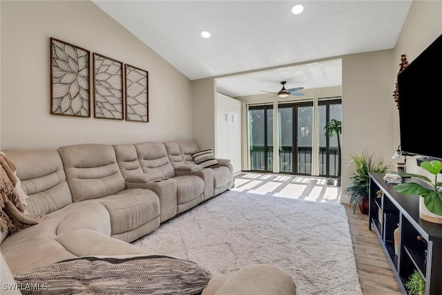 living room featuring ceiling fan, lofted ceiling, and light wood-type flooring