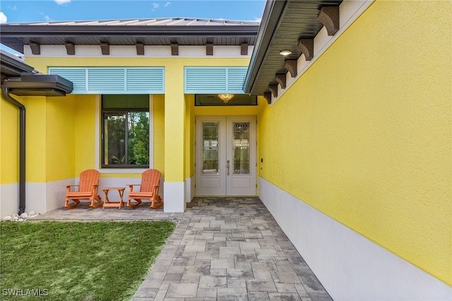 view of exterior entry with a patio area and french doors