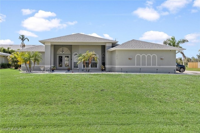 view of front of property with a shingled roof, french doors, a front lawn, and stucco siding