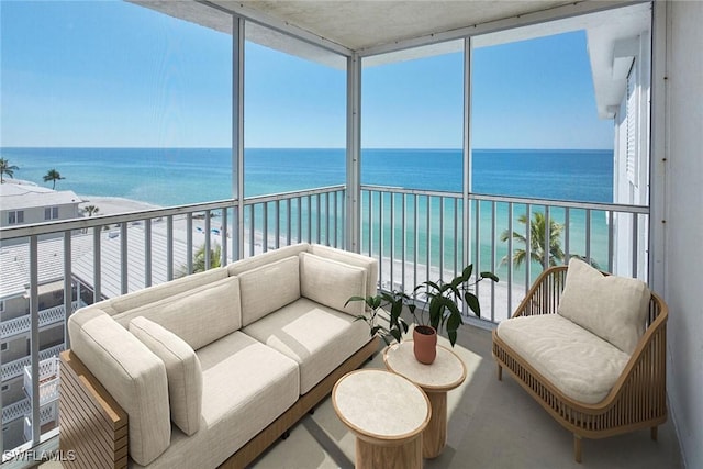 sunroom / solarium featuring a water view and a beach view