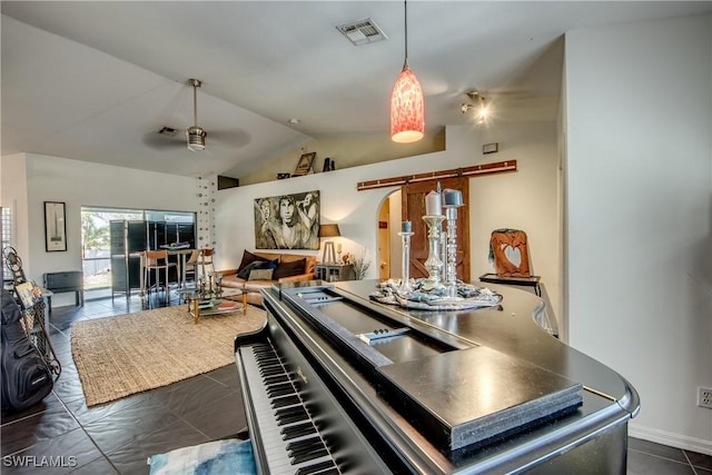 interior space featuring ceiling fan, dark tile patterned flooring, and vaulted ceiling