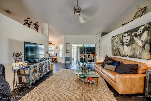 living room featuring ceiling fan and dark tile patterned flooring