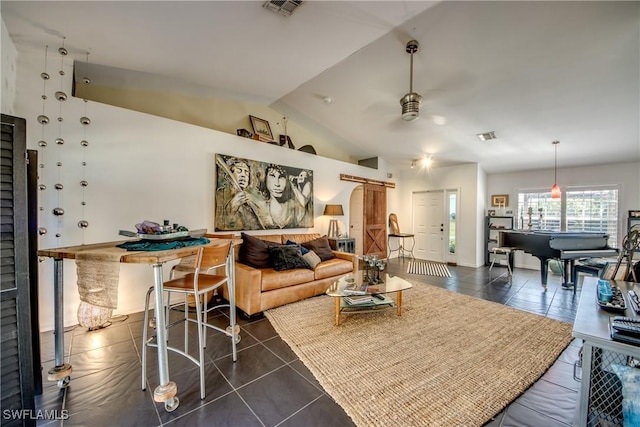 tiled living room with vaulted ceiling, a barn door, and ceiling fan