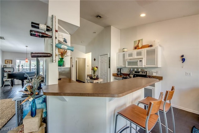 kitchen featuring white cabinetry, a kitchen breakfast bar, and kitchen peninsula