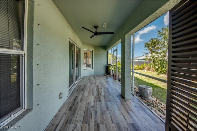 unfurnished sunroom with ceiling fan